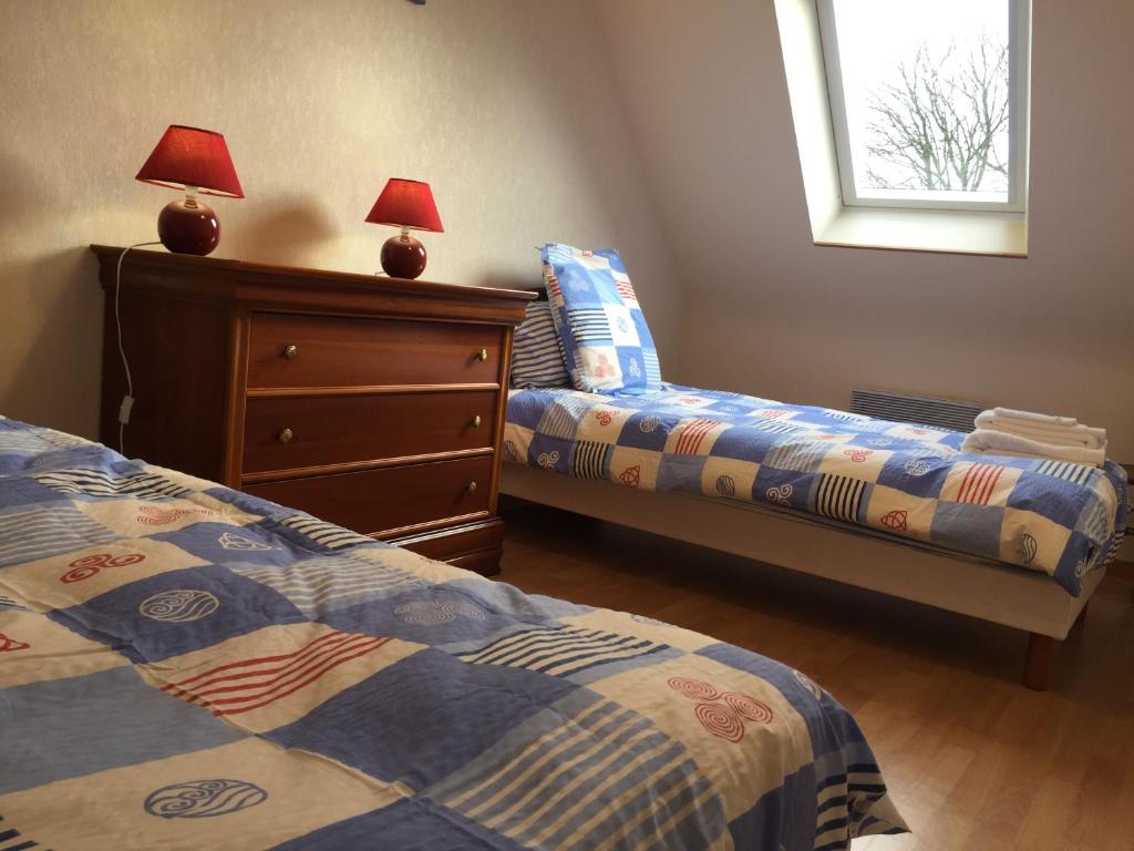 une chambre avec deux lits et une commode et une fenêtre dans l'établissement Gîte Le Penker, à Minihy-Tréguier
