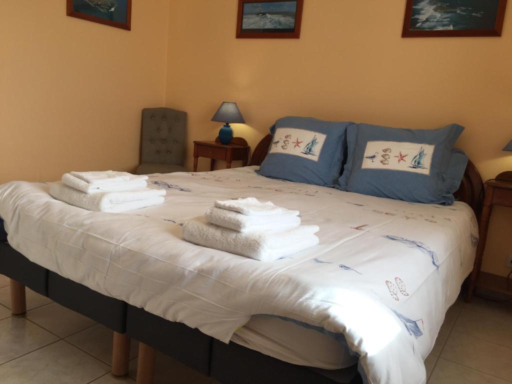 une chambre avec un lit avec des serviettes dessus dans l'établissement Gîte Le Penker, à Minihy-Tréguier