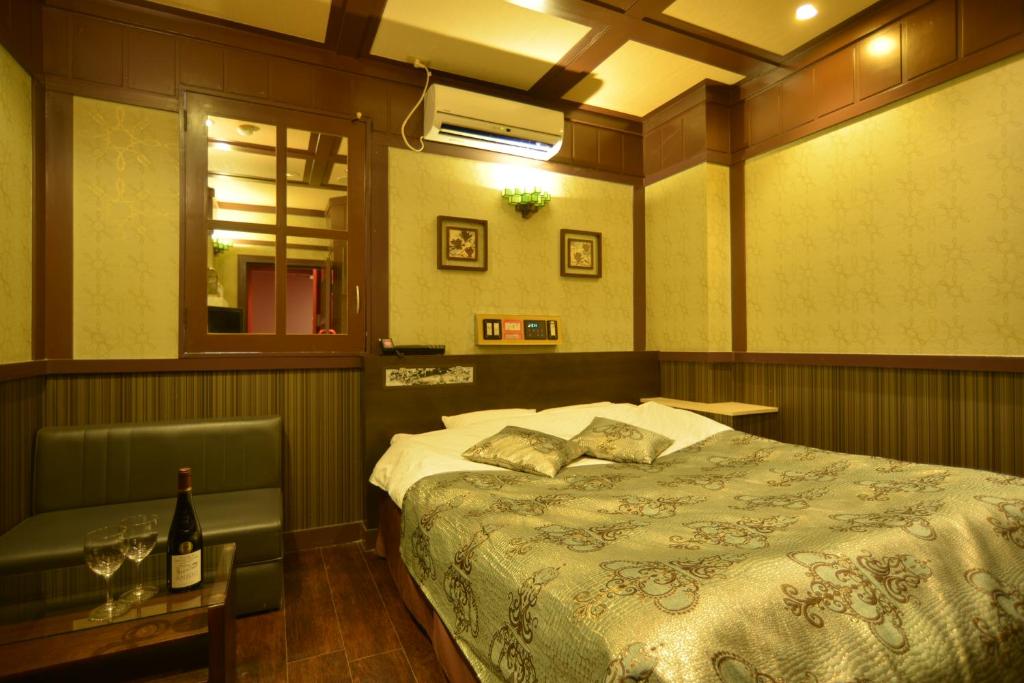 une chambre avec un lit et une bouteille de vin dans l'établissement Restay Kitakami - Adult Only, à Kitakami