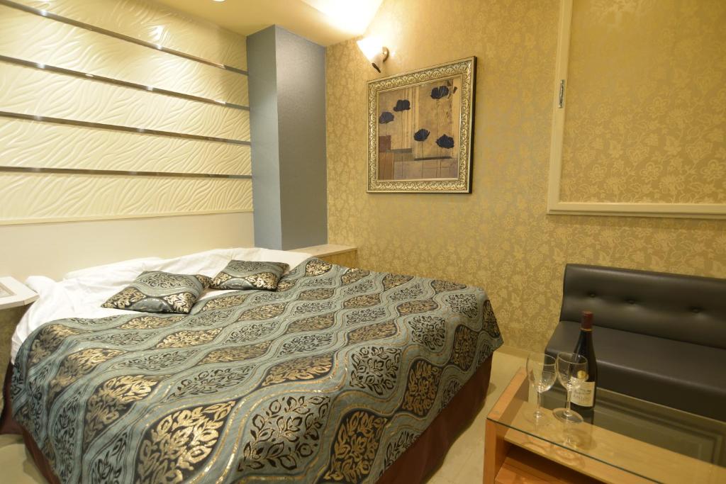 une chambre avec un lit et une table avec une chaise dans l'établissement Restay Kitakami - Adult Only, à Kitakami