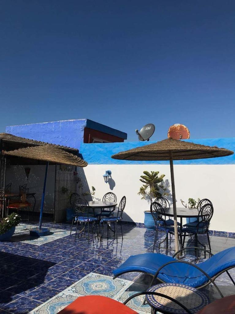 un groupe de tables et de chaises avec parasols dans l'établissement Riad Salmiya Dune, à Essaouira