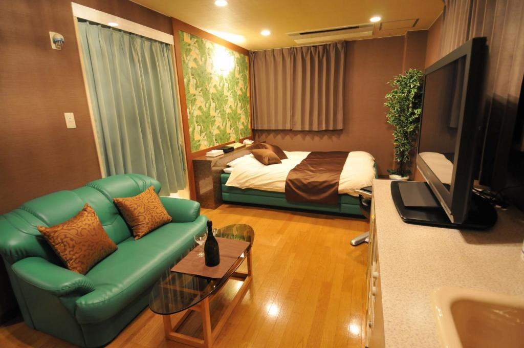 un salon avec un canapé et un lit dans l'établissement Ｈｏｔｅｌkura, à Sodegaura 12 autres photos