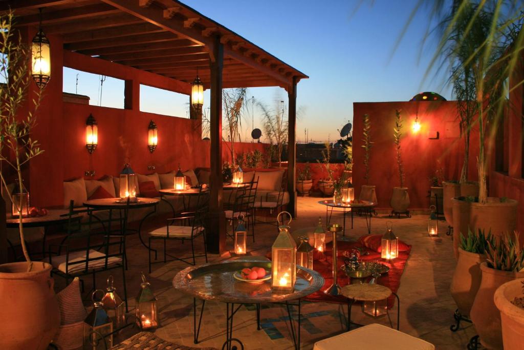 d'une terrasse avec des tables et des chaises et des lumières sur celle-ci. dans l'établissement Riad Honey, à Marrakech