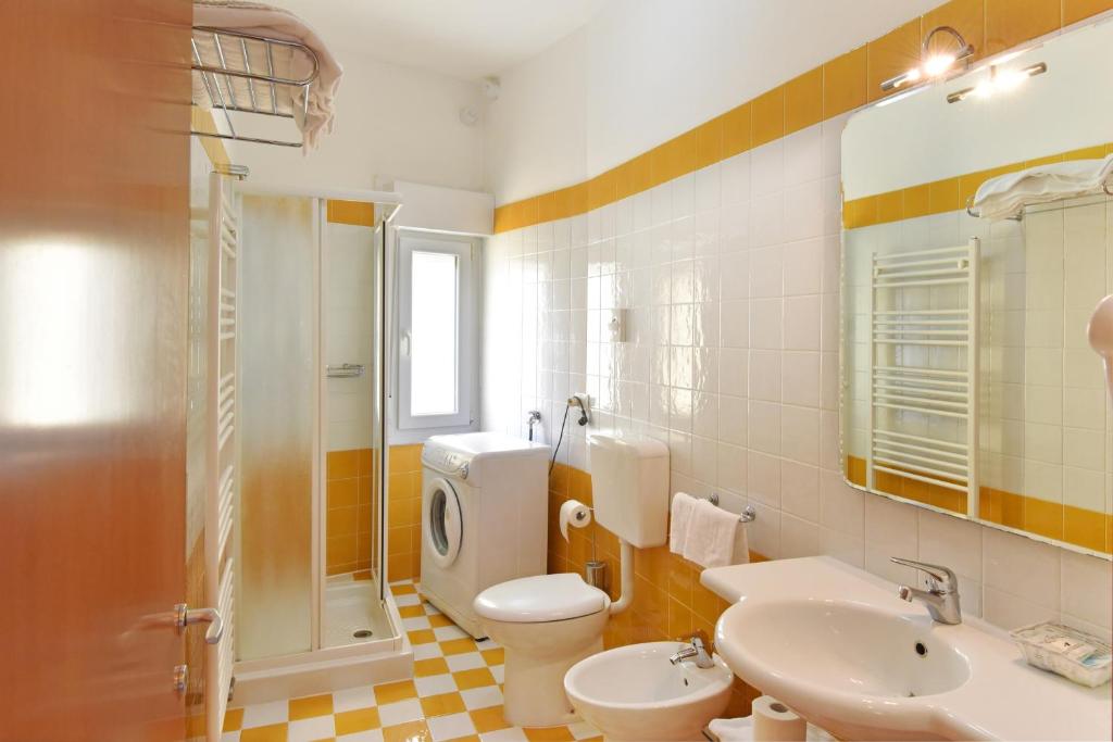 une salle de bain avec toilettes, lavabo et douche dans l'établissement Hotel Villa Olga, à Caorle