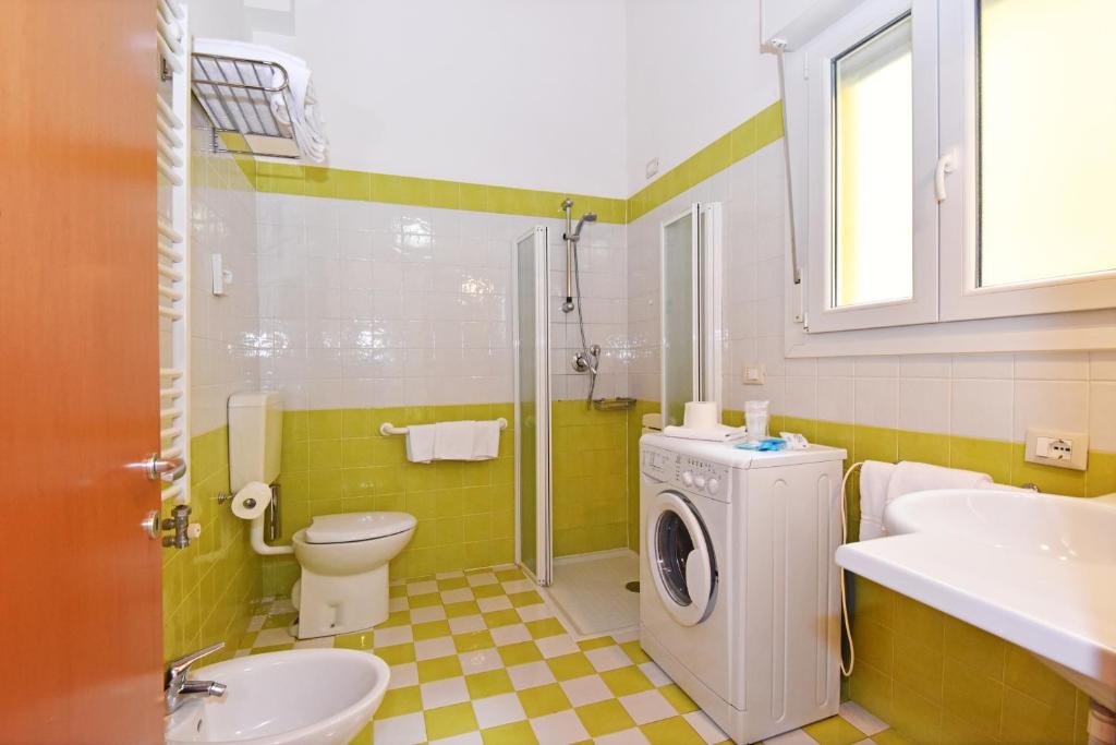 La salle de bains est pourvue de toilettes, d'un lavabo et d'un lave-linge. dans l'établissement Hotel Villa Olga, à Caorle 131 autres photos
