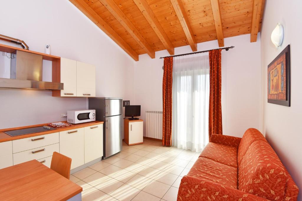 un salon avec un canapé et une cuisine dans l'établissement Hotel Villa Olga, à Caorle