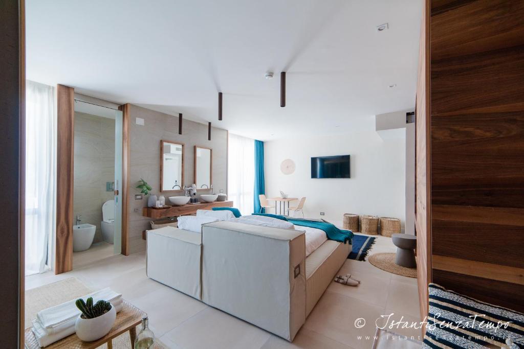 un salon avec un canapé et une salle de bains. dans l'établissement Cumeja Beach Club & Hotel, à Baia Domizia