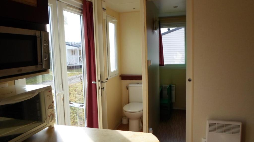 Elle comprend une petite salle de bains pourvue de toilettes et d'une fenêtre. dans l'établissement Camping les Pinasses, à La Chapelle