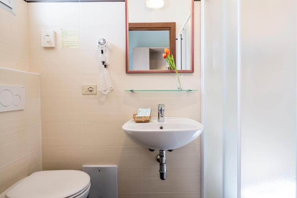une salle de bain avec un lavabo et des toilettes dans l'établissement Hotel Belmar, à Rimini