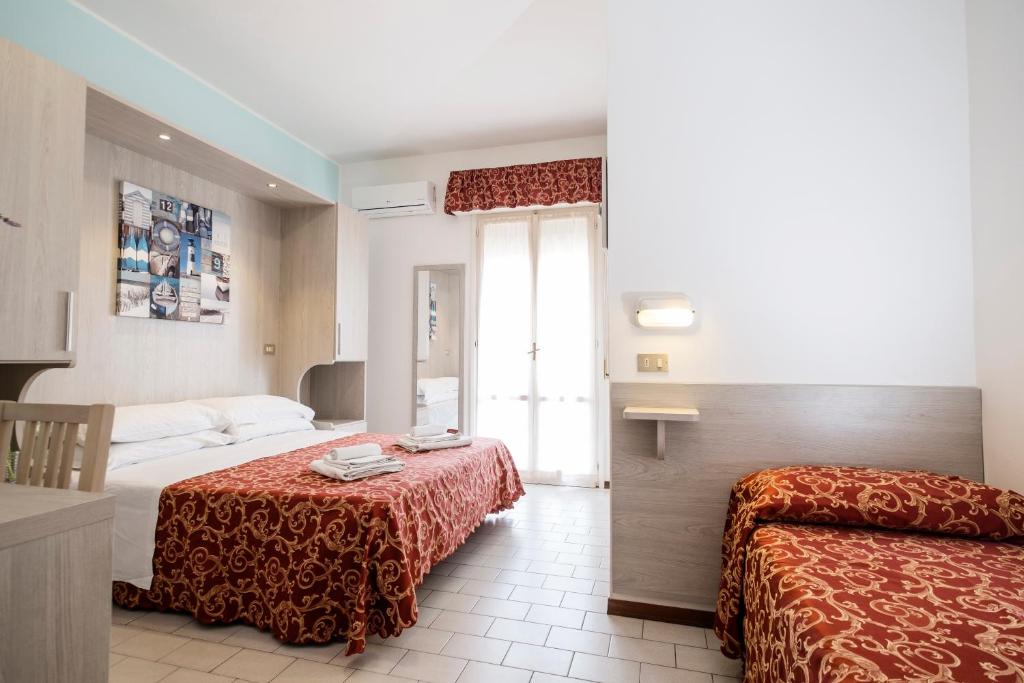 une chambre d'hôtel avec deux lits et une fenêtre dans l'établissement Hotel Belmar, à Rimini