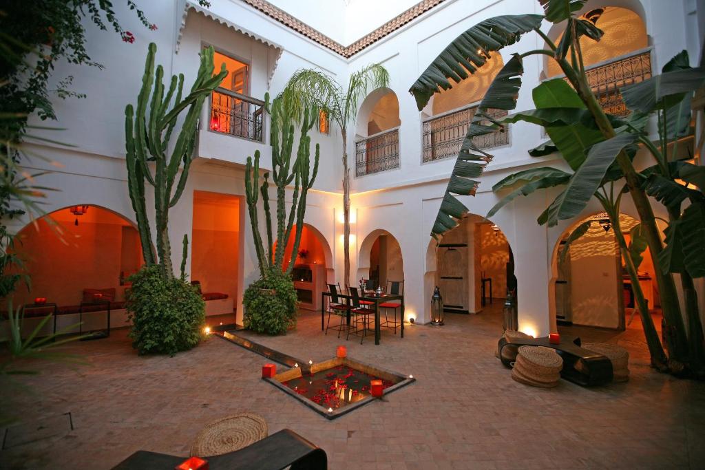 une cour intérieure avec des plantes, une table et des chaises dans l'établissement Riad O2, à Marrakech