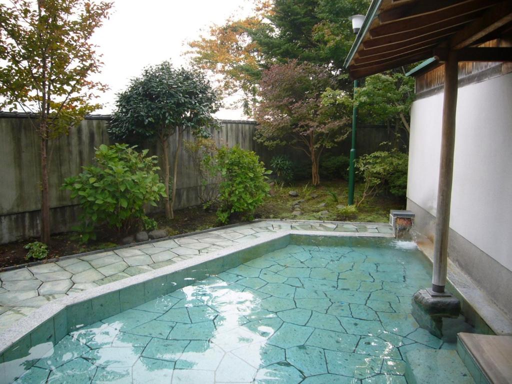 - une piscine dans une arrière-cour avec une clôture dans l'établissement Ikaho Grand Hotel, à Shibukawa 21 autres photos