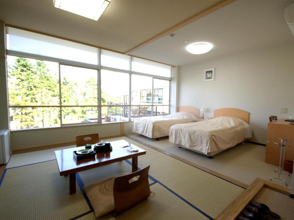 une chambre avec deux lits et une table avec une table sidx sidx sidx dans l'établissement Kindayu, à Shibukawa
