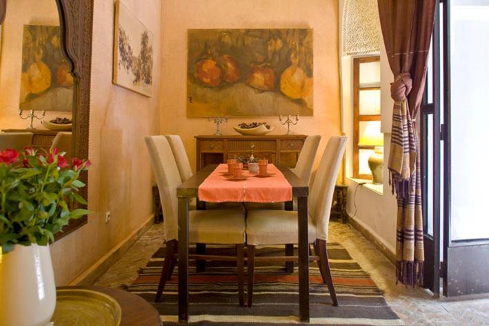 une salle à manger avec une table et des chaises dans une pièce dans l'établissement Dar Attajmil, à Marrakech