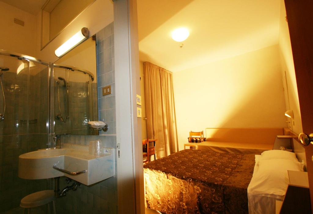 une salle de bain avec une douche et un lavabo et un lit dans l'établissement Hotel Caesar, à Rimini 24 autres photos