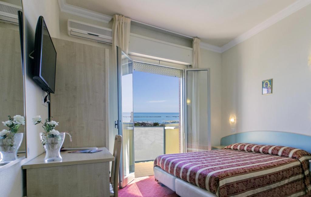 une chambre avec un lit et une porte coulissante en verre dans l'établissement Hotel Silver, à Cesenatico 13 autres photos