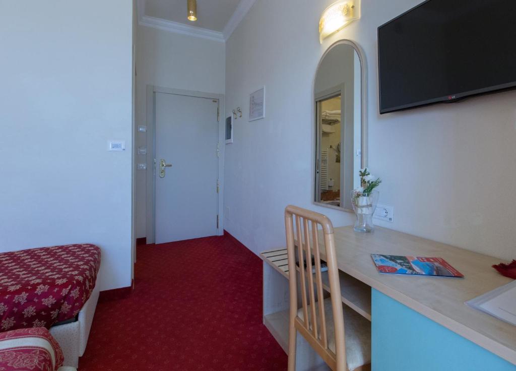 Cette chambre dispose d'un lavabo et d'un bureau avec un miroir. dans l'établissement Hotel Silver, à Cesenatico