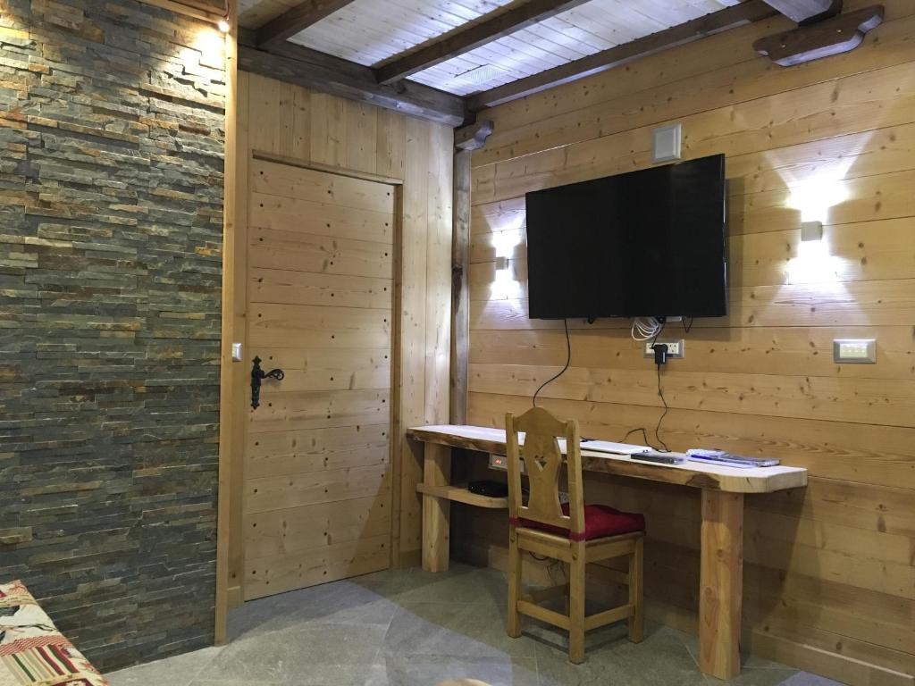 Cette chambre dispose d'un bureau et d'une télévision murale. dans l'établissement Le grenier des rêves, à Les Deux Alpes