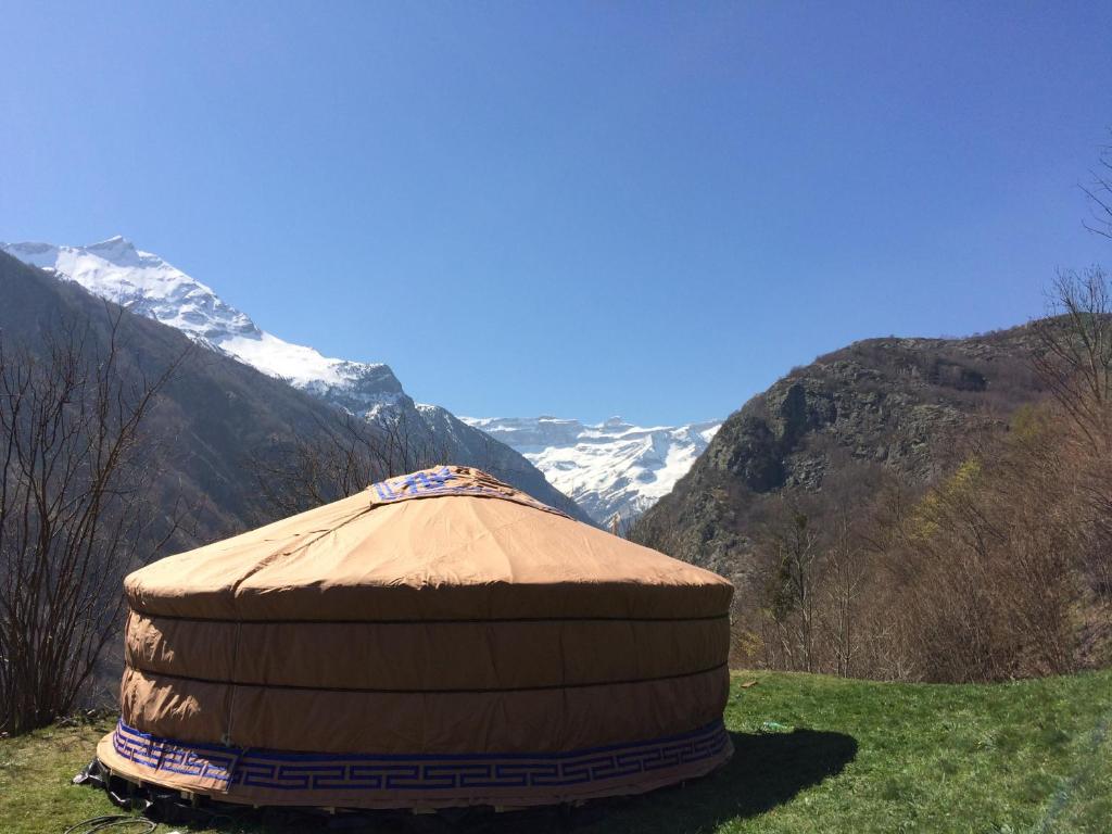 une yourte dans un champ avec des montagnes en arrière-plan dans l'établissement Yourtes Mongoles Gavarnie, à Gèdre 9 autres photos