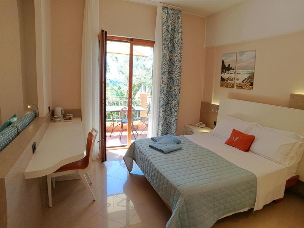 une chambre avec un lit, une table et une fenêtre dans l'établissement Hotel Residence Piccolo, à Parghelia