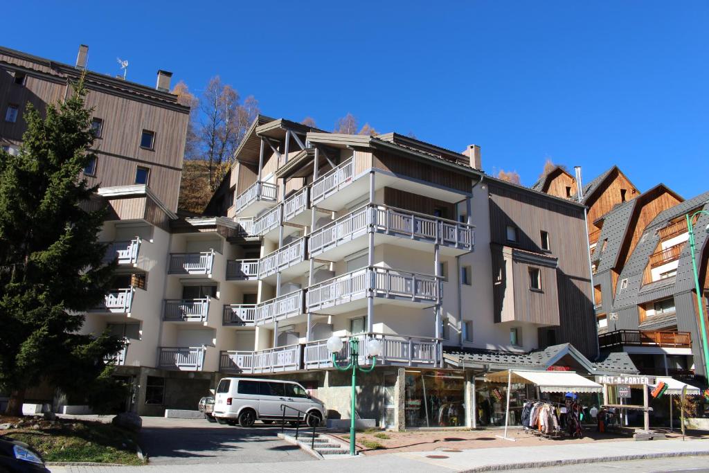 une camionnette blanche garée devant un immeuble dans l'établissement Kandahar 202 - Les Deux Alpes- Plein centre-station, 32m2, à Les Deux Alpes