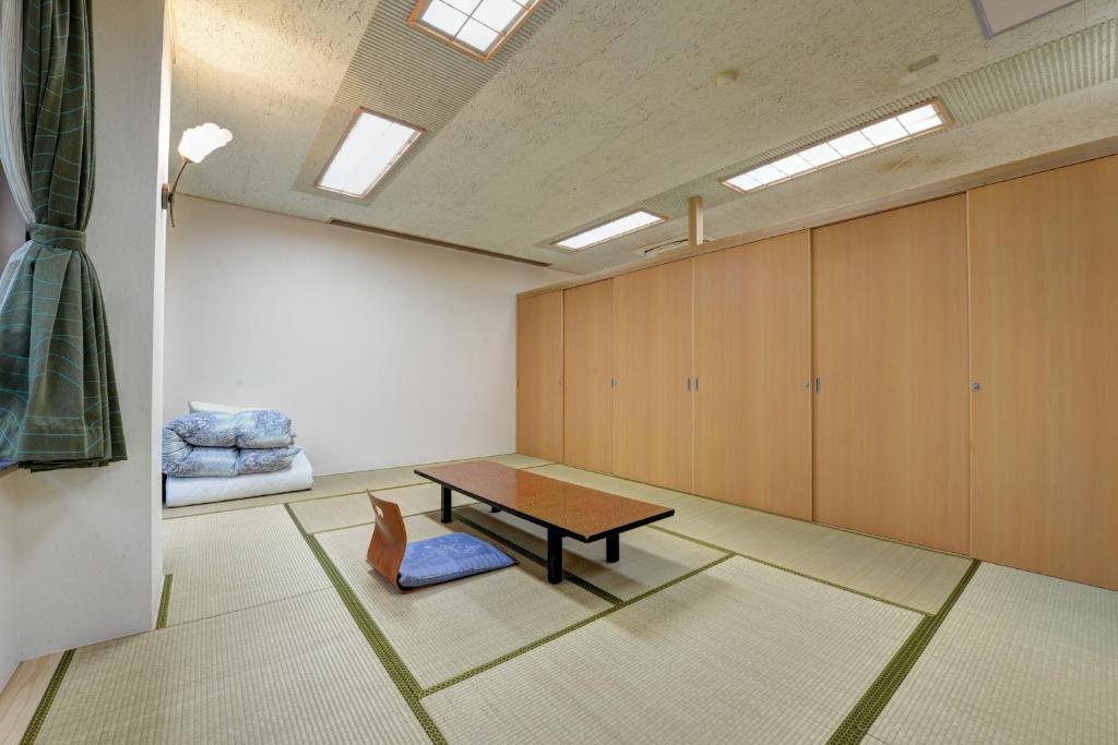 une chambre avec une table, un banc et des armoires dans l'établissement Mizu no Kaori, à Hakone 111 autres photos