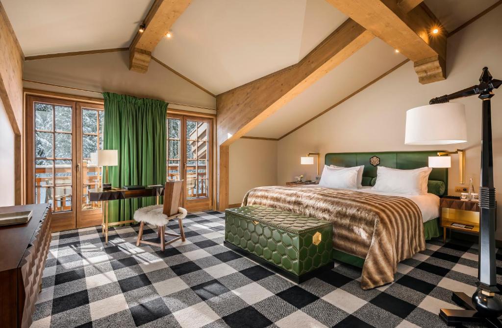 - une chambre avec un lit vert et un bureau dans l'établissement Apogée Courchevel, Oetker Hotels, à Courchevel