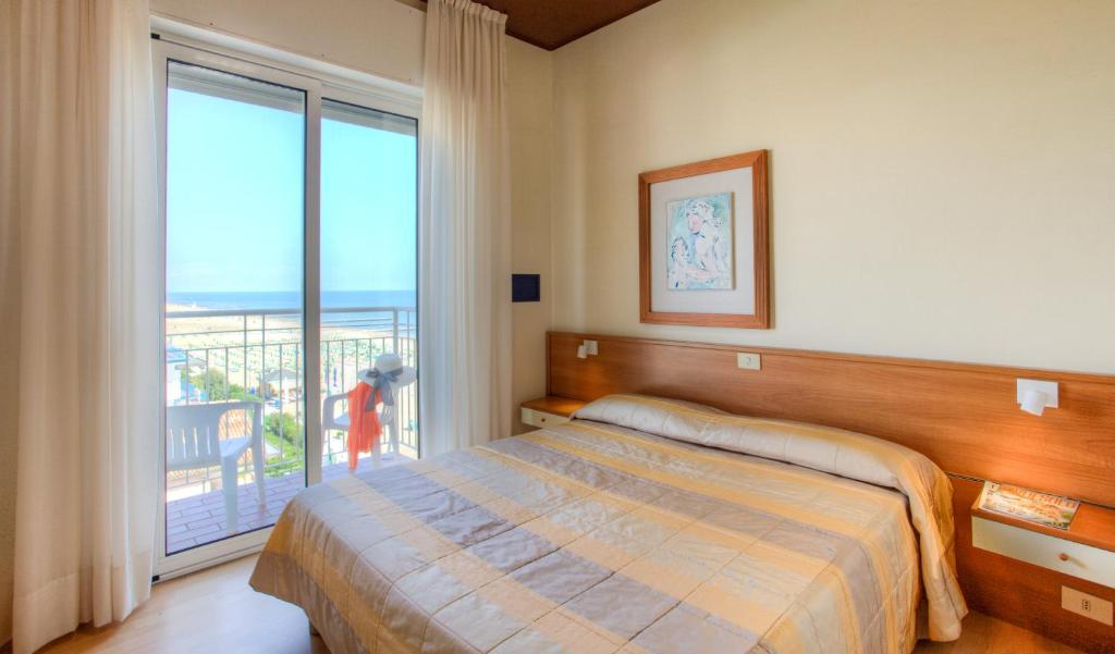 une chambre avec un lit et une grande fenêtre dans l'établissement Hotel Ancora, à Lido di Jesolo