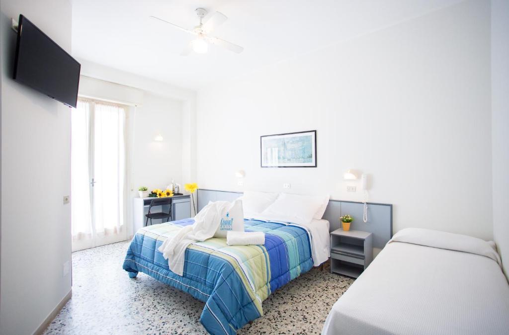 une chambre blanche avec un lit et une fenêtre dans l'établissement Hotel Confort, à Cattolica