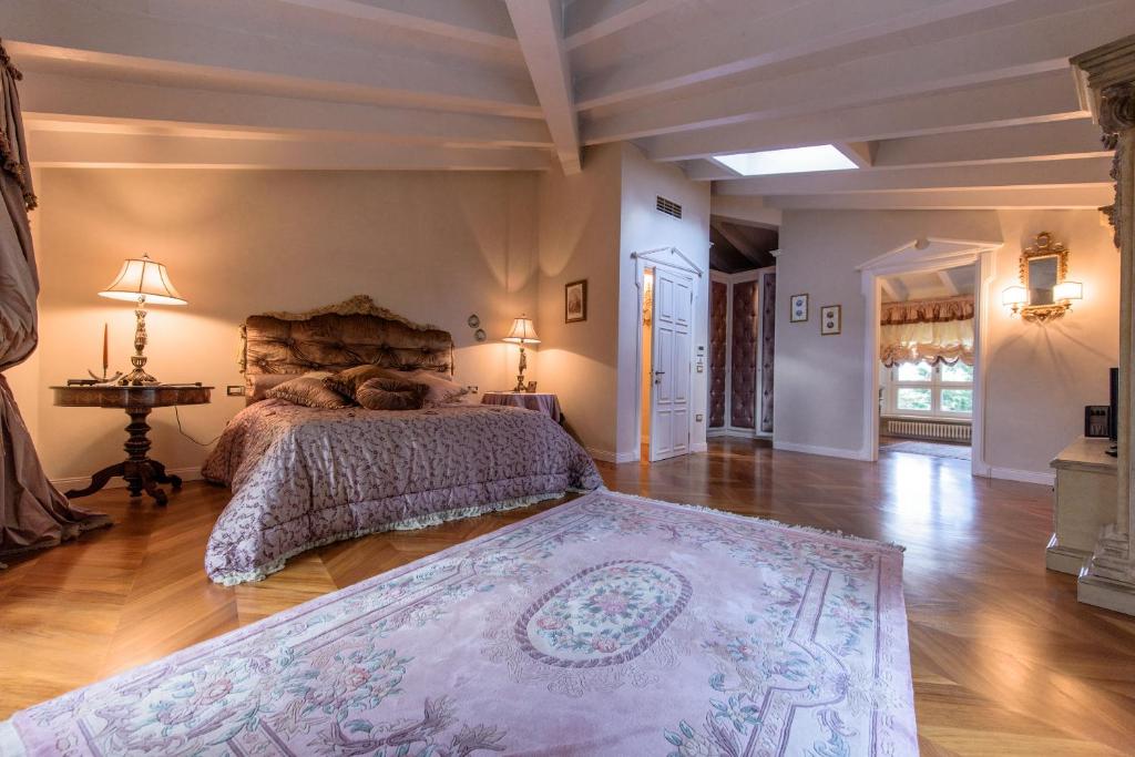 une chambre avec un grand lit et un parquet dans l'établissement Villa Rinaldi, à Montespertoli