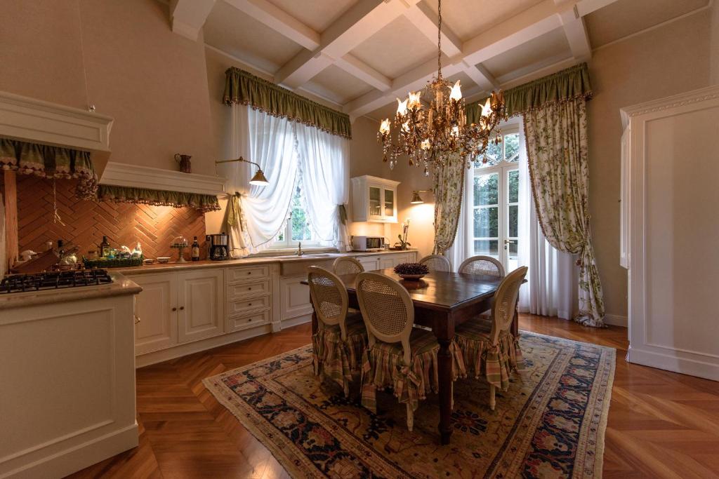 une cuisine avec une table et des chaises ainsi qu'un lustre dans l'établissement Villa Rinaldi, à Montespertoli
