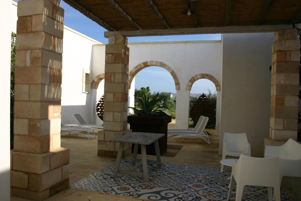 d'une terrasse avec des chaises blanches et une table. dans l'établissement Agriturismo Vigna Corallo, à Otrante