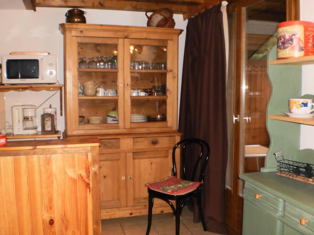 une cuisine avec une cabane en bois et une chaise dans l'établissement Location Montagne, aux Contamines-Montjoie 8 autres photos