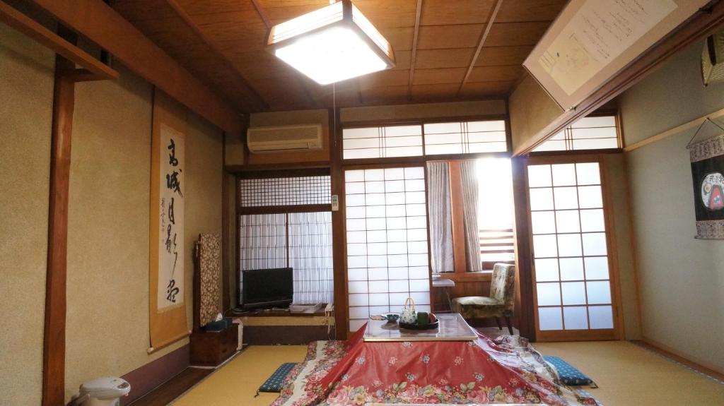 - un salon avec une table dans une pièce dotée de fenêtres dans l'établissement Ougiya Ryokan, à Toyooka