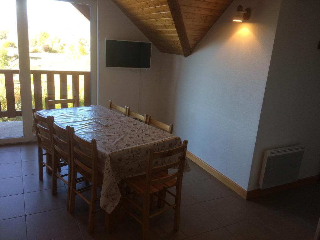 une salle à manger avec une table et des chaises dans l'établissement Résidence Les Ecrins, à Ancelle