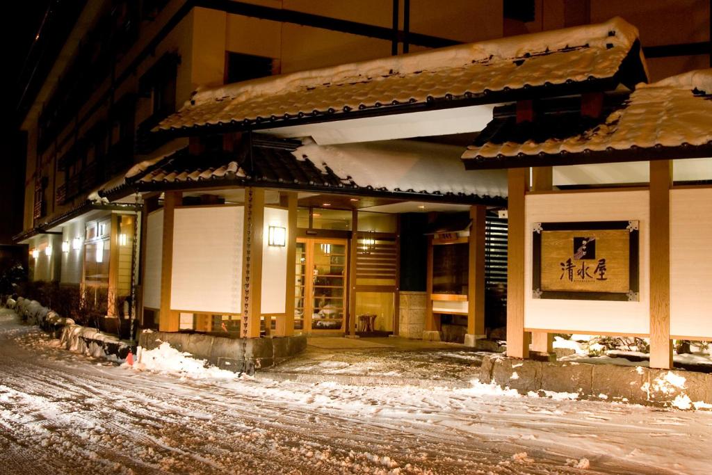 - un bâtiment dans une rue enneigée la nuit dans l'établissement Oyado Kiyomizuya, à Noboribetsu