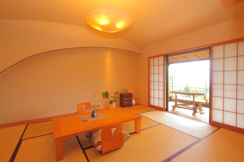 un salon avec une table et une fenêtre dans l'établissement Nasubi no Hana, à Itō 19 autres photos