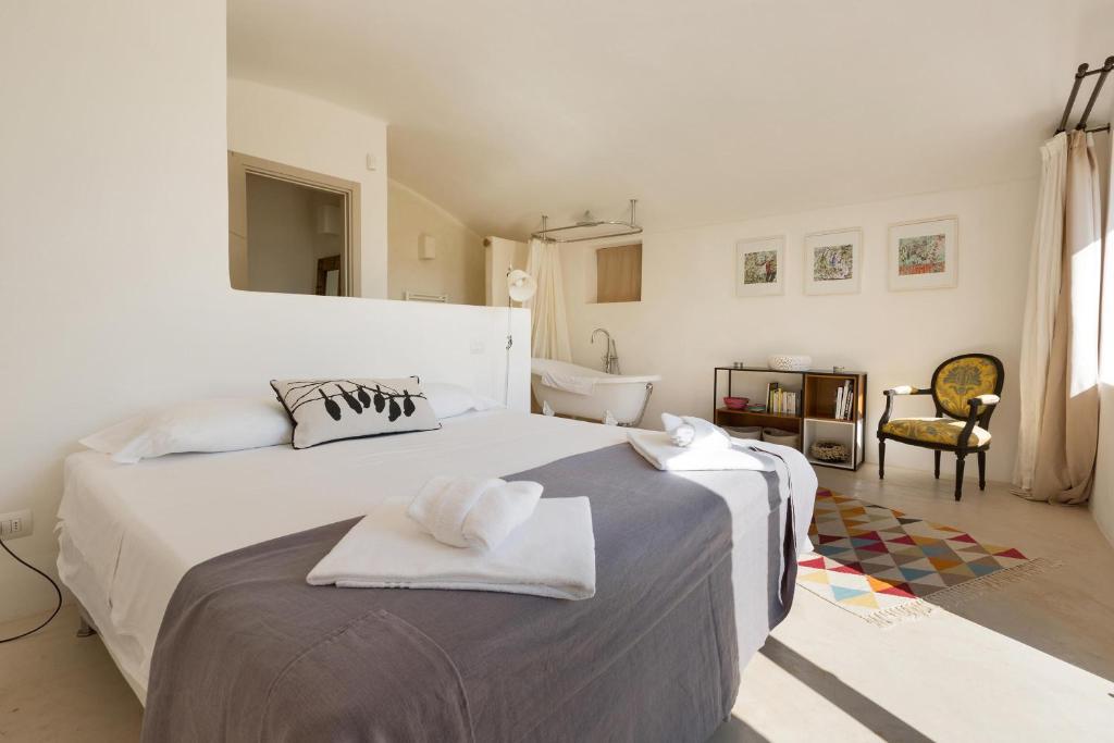 une chambre blanche avec deux lits avec des serviettes dessus dans l'établissement La Gastalena by BarbarHouse, à Ostuni 40 autres photos