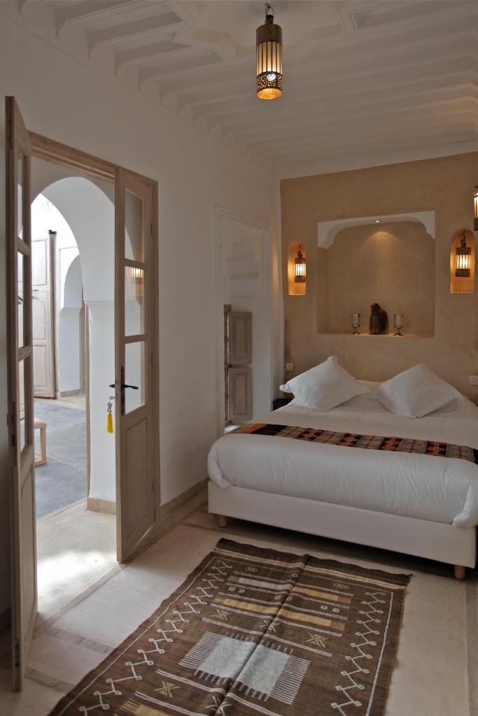 - une chambre avec un grand lit et une porte ouverte dans l'établissement Riad Dar Ten, à Marrakech