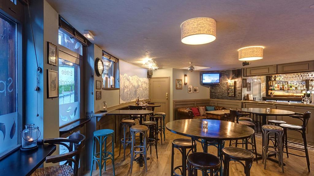 un restaurant avec des tables et des chaises et un bar dans l'établissement Plagne Bellecote Apartments, à Plagne Bellecôte
