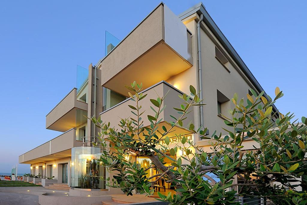 un grand bâtiment avec des arbres devant dans l'établissement Hotel & Residence Cavalluccio Marino, à Rimini