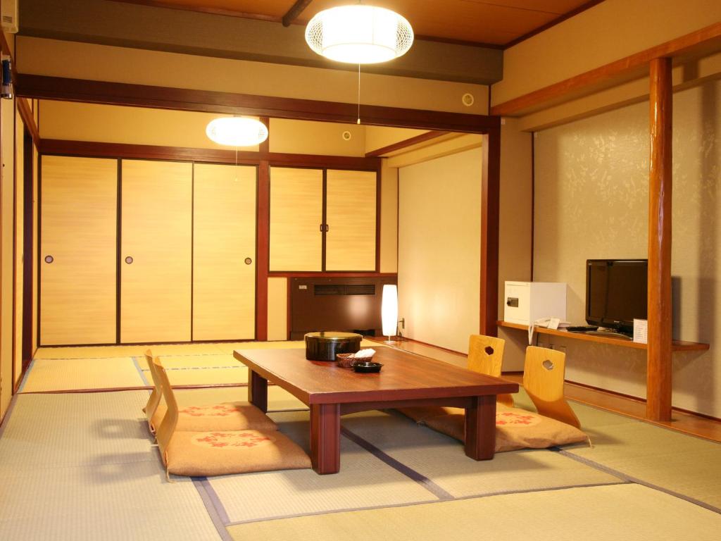 un salon avec une table et des chaises en bois dans l'établissement Hotel Kirishima Castle, à Kirishima
