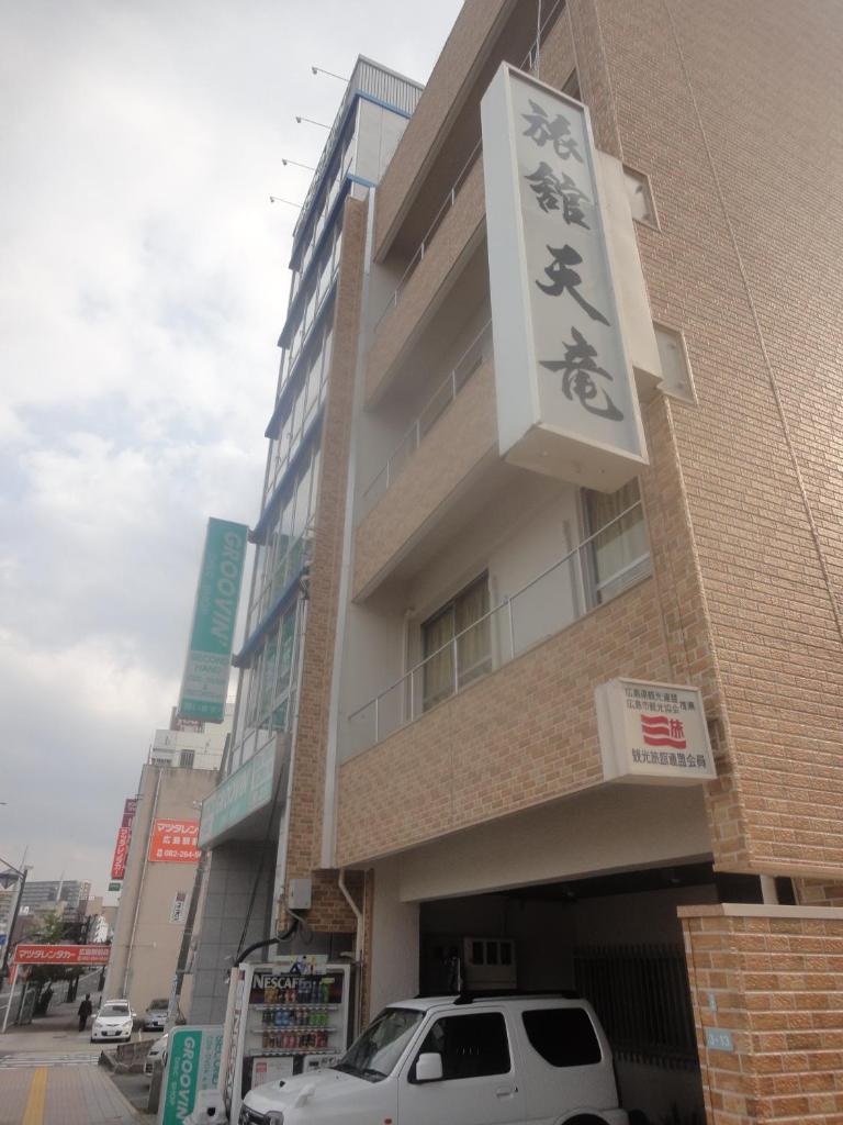 un bâtiment avec une enseigne sur le côté dans l'établissement Tenryu Ryokan, à Hiroshima