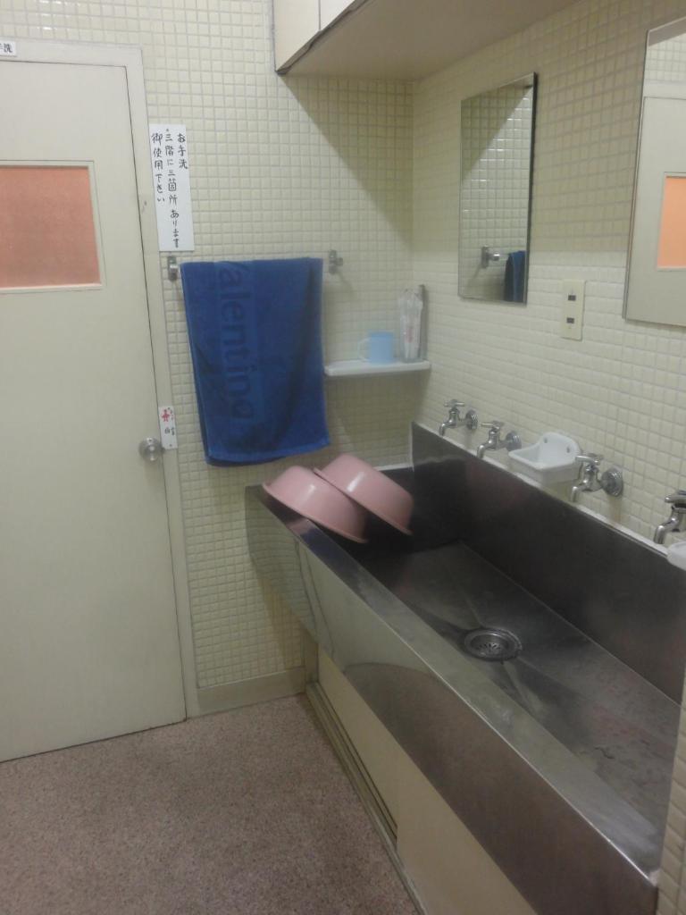 La salle de bains est pourvue d'un lavabo et d'une serviette bleue. dans l'établissement Tenryu Ryokan, à Hiroshima 18 autres photos