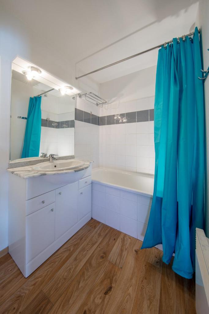 une salle de bain avec une baignoire, un lavabo et un miroir dans l'établissement Les Cimes Du Val D'Allos, à La Foux
