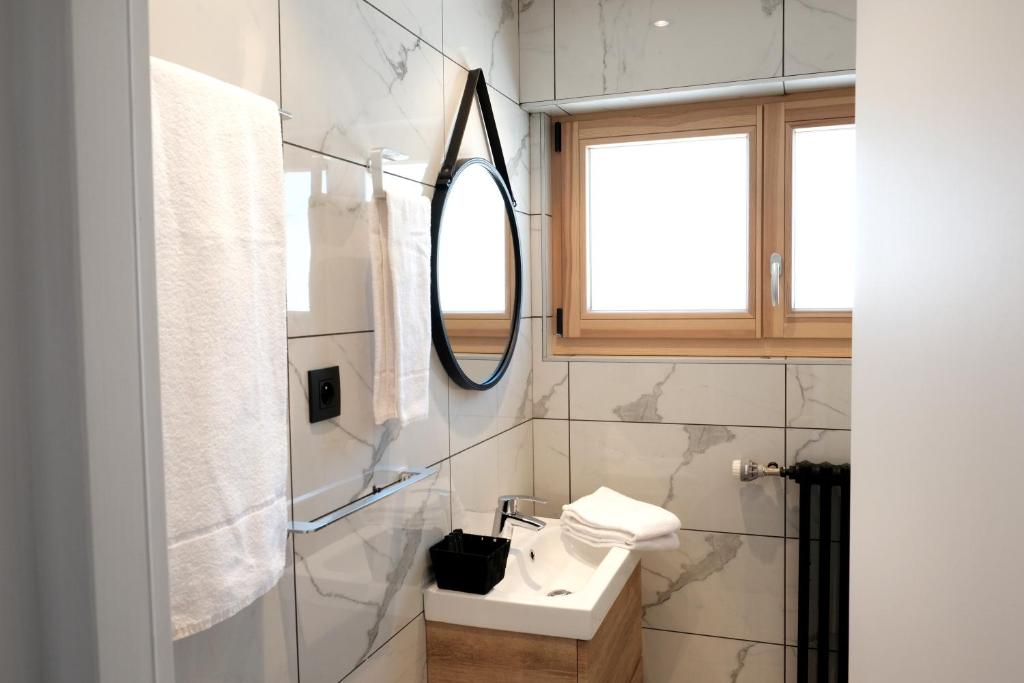 une salle de bain avec un lavabo et un miroir dans l'établissement Hôtel La Grande Lanière, aux Gets