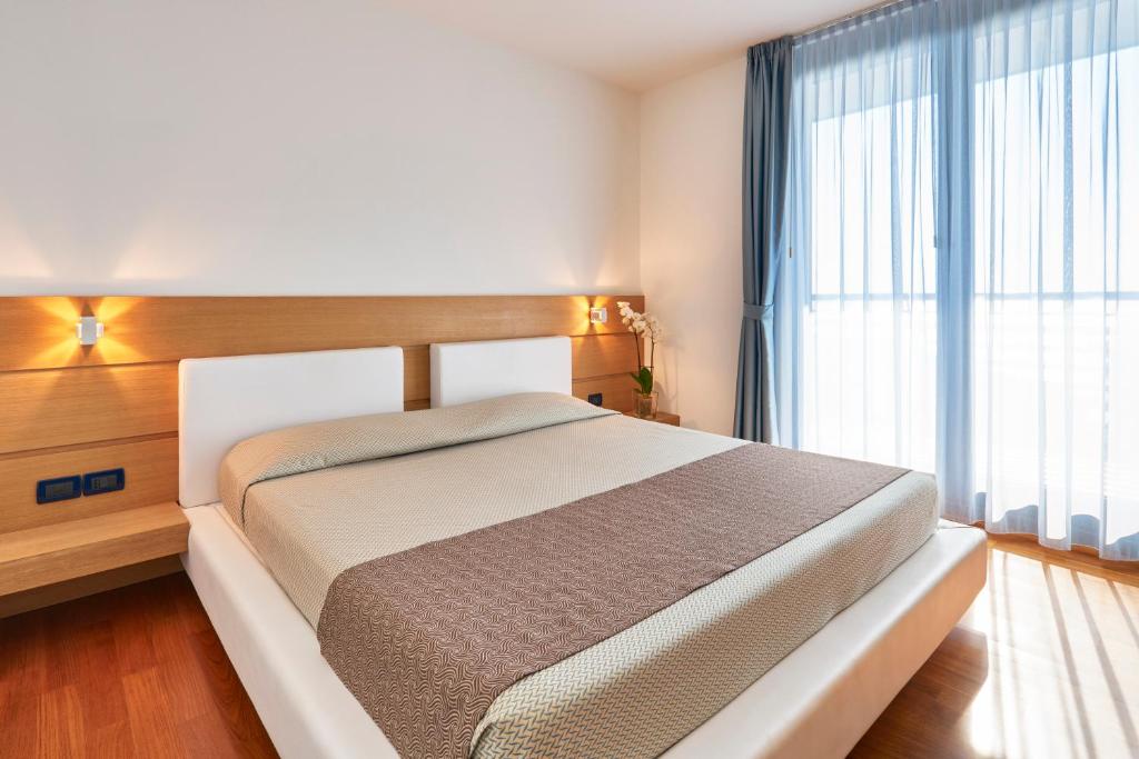 une chambre avec un lit et une grande fenêtre dans l'établissement Hotel Fonzari, à Grado