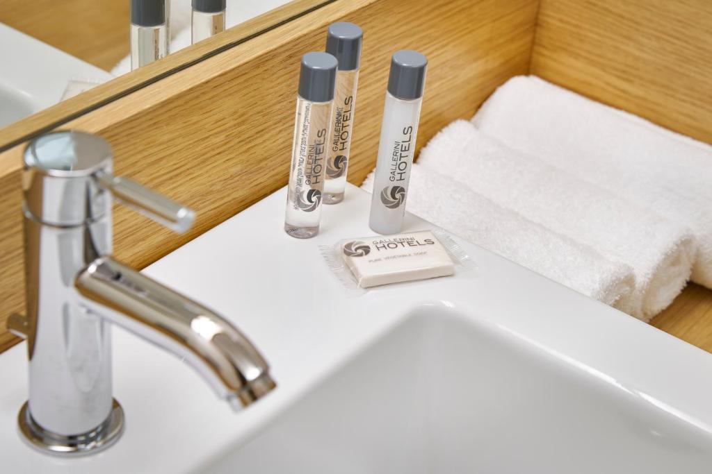 - un lavabo avec 2 brosses à dents et des serviettes dans l'établissement Hotel Fonzari, à Grado