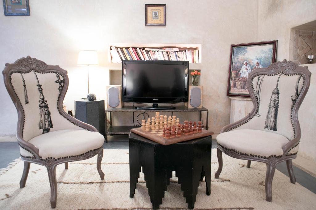 - un salon avec deux chaises et un échiquier sur une table dans l'établissement Riad Dar More, à Marrakech