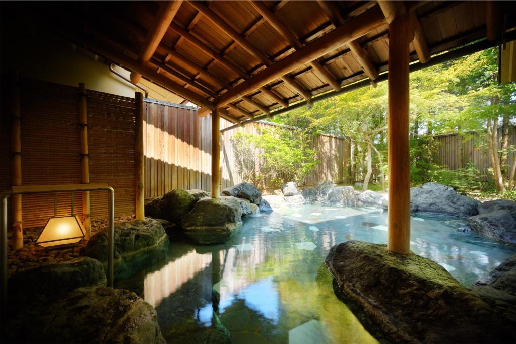 une piscine d'eau avec des rochers dans une maison dans l'établissement Saryo Souen, à Sendai